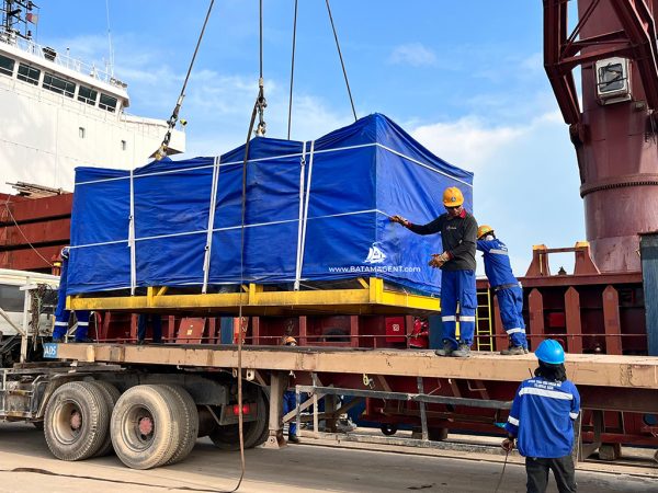 Stevedoring company workers are positioning the cargo to be loaded onto a trailer during the unloading operation at Batu Ampar Port. The operation was coordinated by Batam Shipping Agency