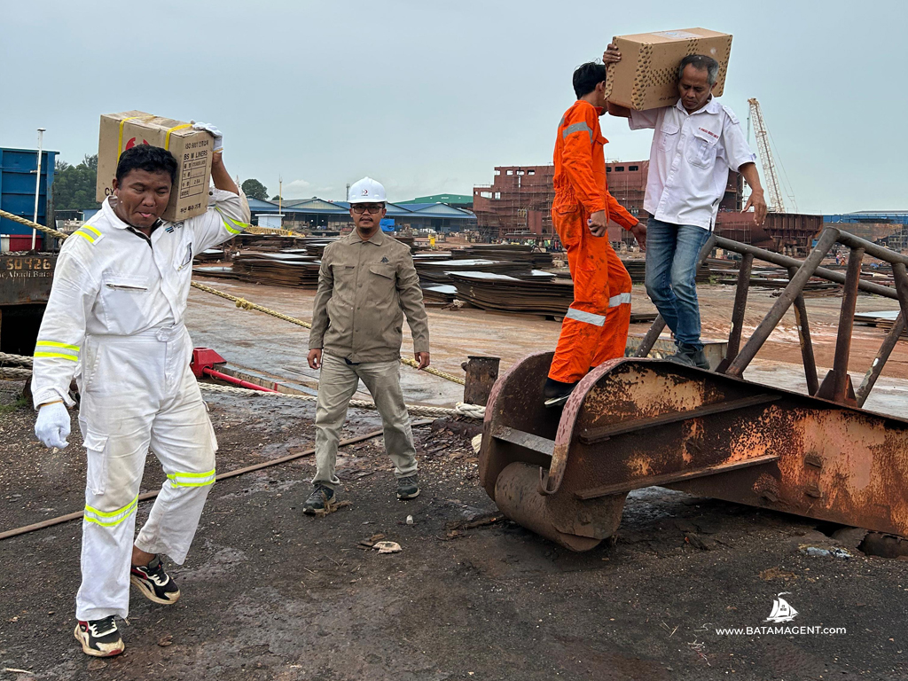 Staff from PT. Bisa Jasa Segara, known as Batam Shipping Agency, overseeing the crew of chemical tanker Zaman Baru lifting new ship spares during docking repair at a Batam shipyard.