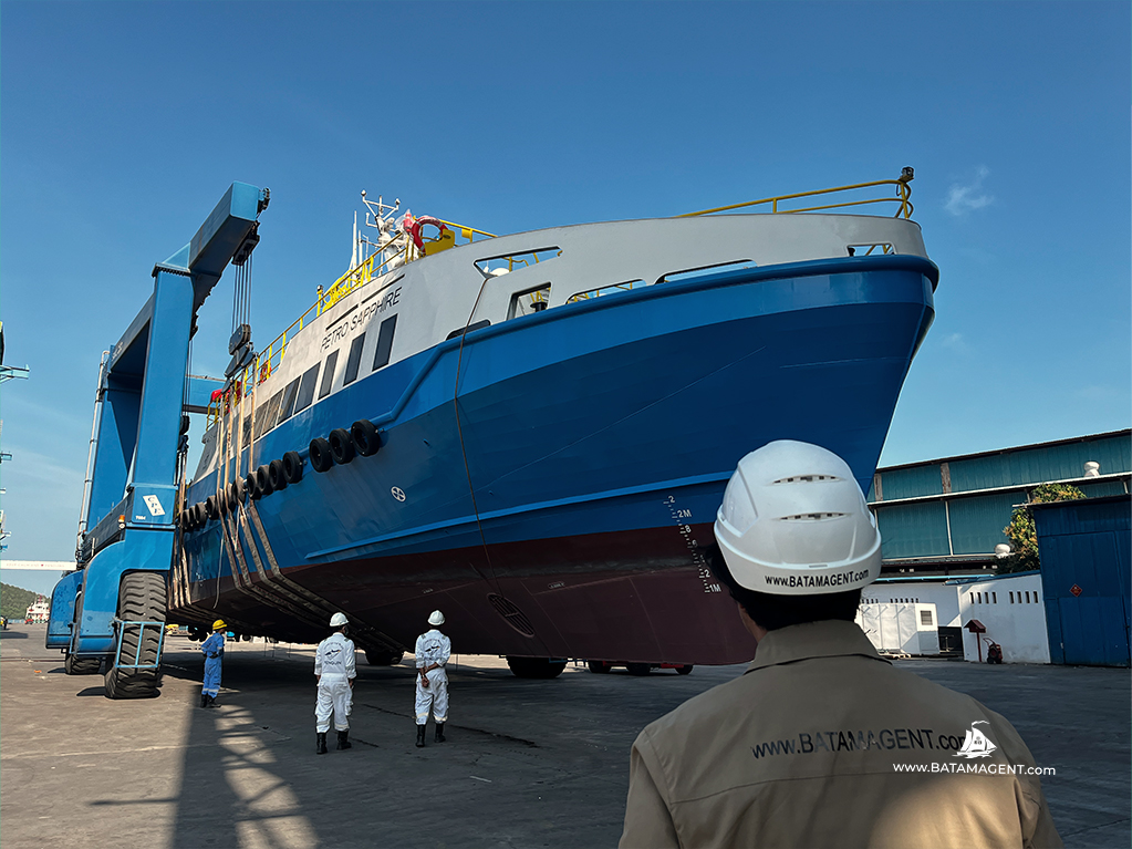 Batam Shipping Agency personnel monitoring vessel transfer using mobile boat hoist at Batam shipyard for Petro Saphire