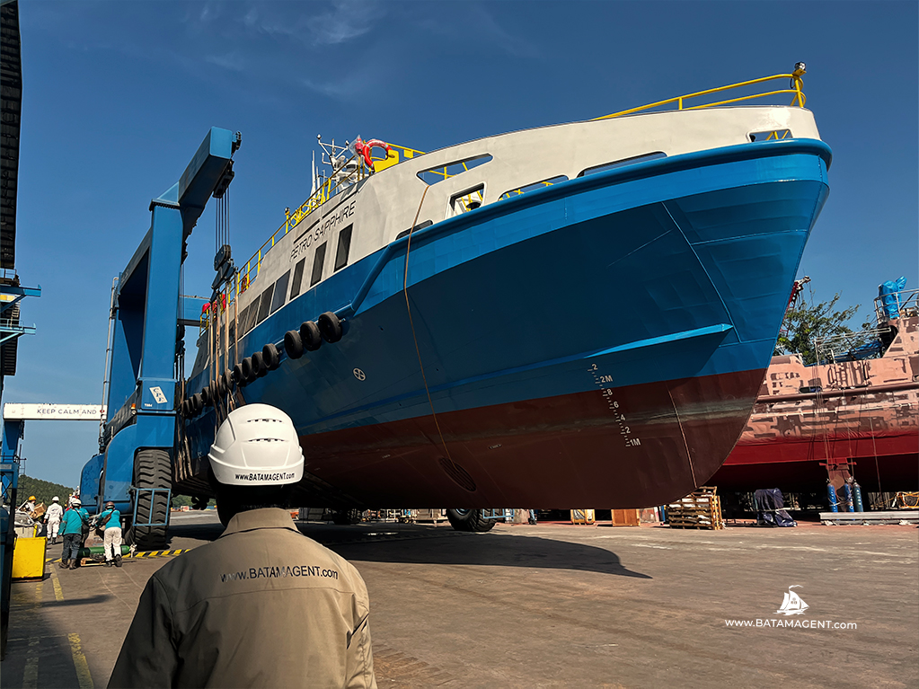 Fast Crew Boat Petro Saphire being lifted and moved by mobile boat hoist in Batam shipyard Indonesia