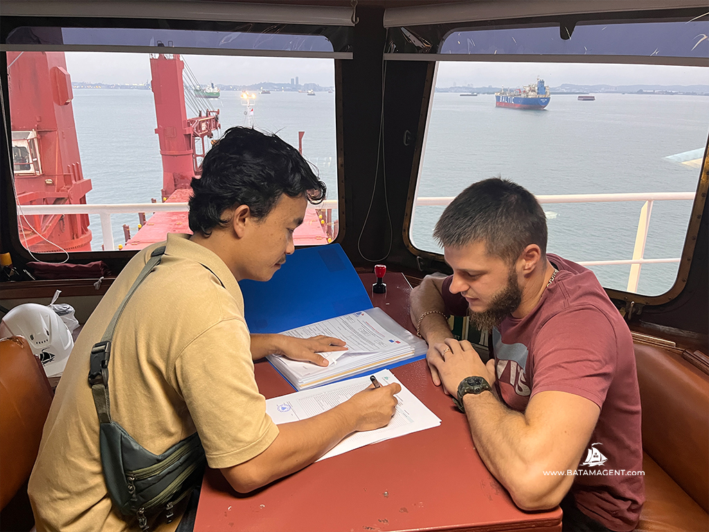 Batam Shipping Agency representative handing vessel documents to the Chief Officer of MV. River Mas.